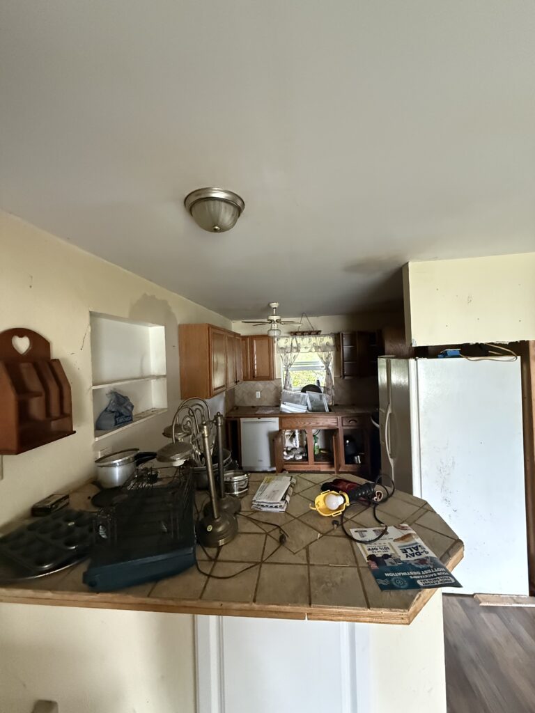 Cluttered kitchen with belongings left behind by the previous owner